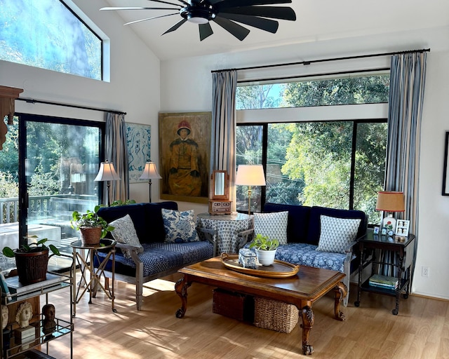 living room with light hardwood / wood-style floors, high vaulted ceiling, and ceiling fan