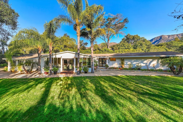 rear view of property featuring a yard and a mountain view