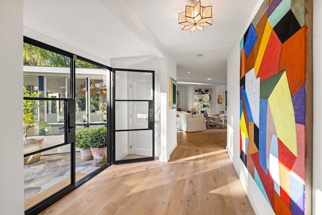 entrance foyer with french doors, light wood-type flooring, and expansive windows