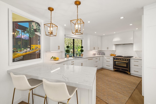 kitchen with kitchen peninsula, pendant lighting, and white cabinetry