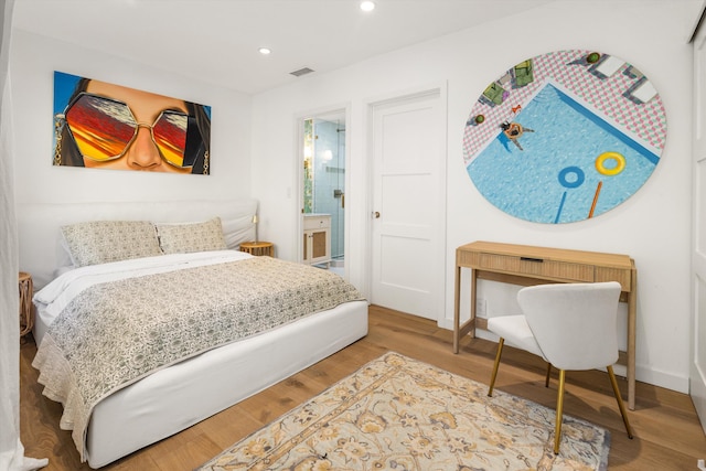 bedroom featuring hardwood / wood-style floors and connected bathroom