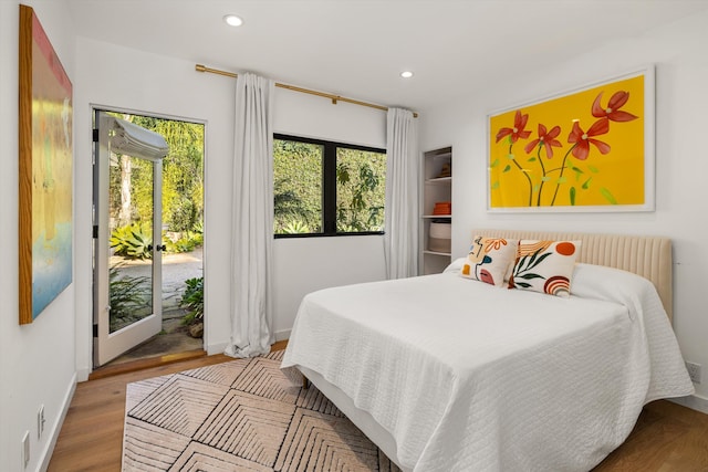 bedroom with french doors, light wood-type flooring, and access to outside