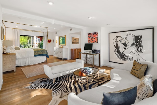 bedroom featuring beam ceiling and light hardwood / wood-style flooring