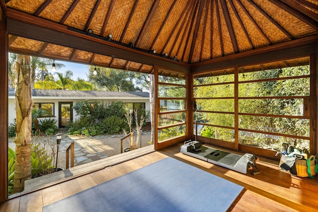 sunroom featuring vaulted ceiling with beams