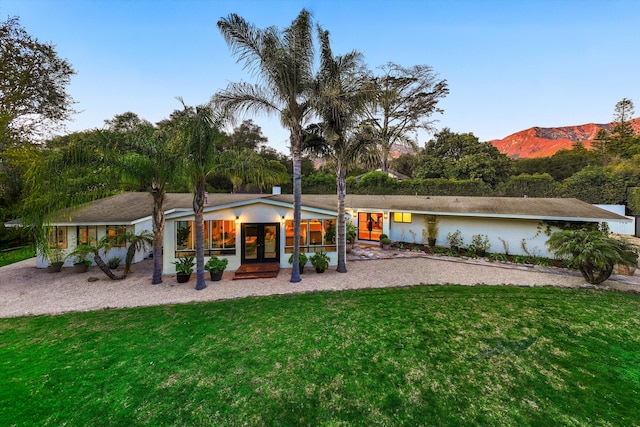 view of front of property with a front lawn and a mountain view