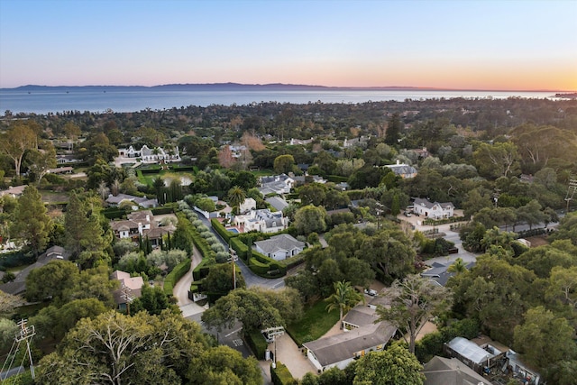 aerial view at dusk featuring a water view