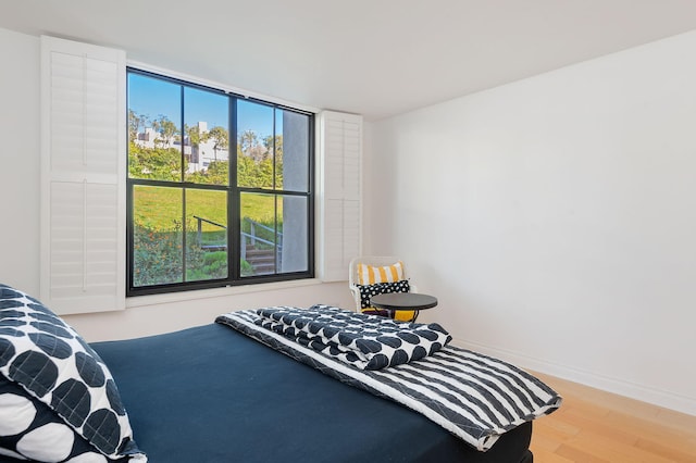 bedroom featuring wood-type flooring and multiple windows