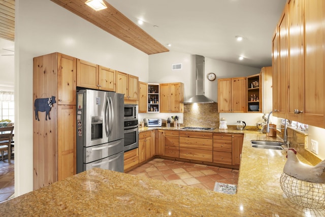 kitchen with sink, wall chimney exhaust hood, light stone countertops, tasteful backsplash, and stainless steel appliances