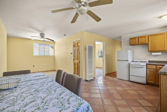 bedroom featuring tile patterned floors, ceiling fan, and white fridge