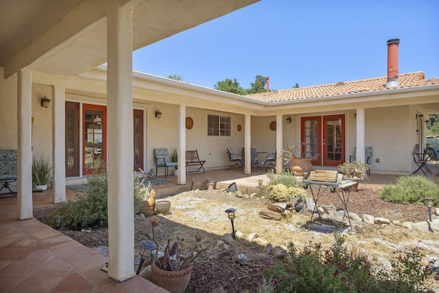 exterior space with covered porch and french doors