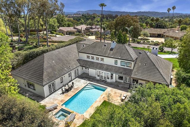 4530 Via Clarice, Santa Barbara, CA 93111 - rear view of house with french doors, a patio area, a chimney, a mountain view, and a pool with connected hot tub