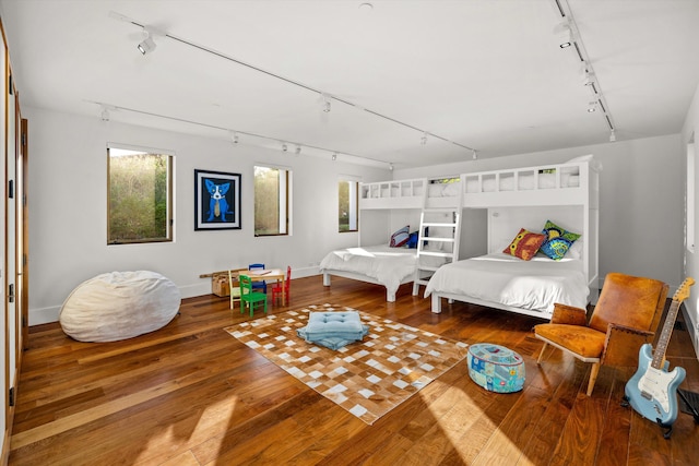 bedroom featuring track lighting and hardwood / wood-style flooring