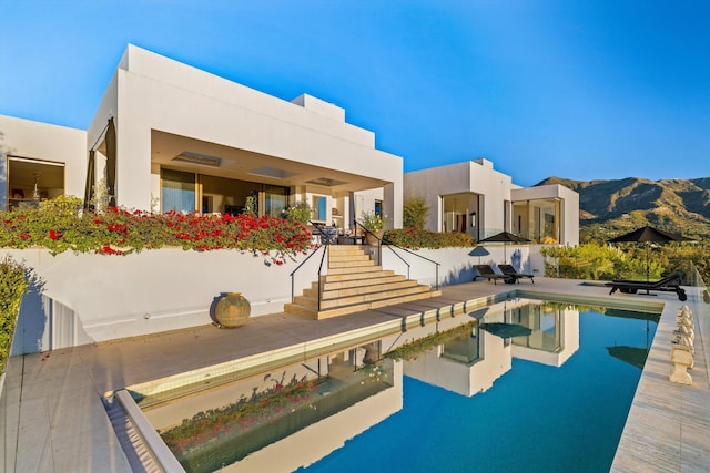 view of swimming pool with a mountain view and a patio