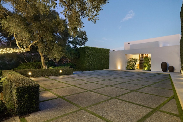 pool at dusk featuring a patio