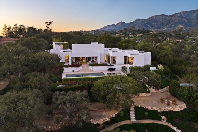 aerial view at dusk featuring a mountain view