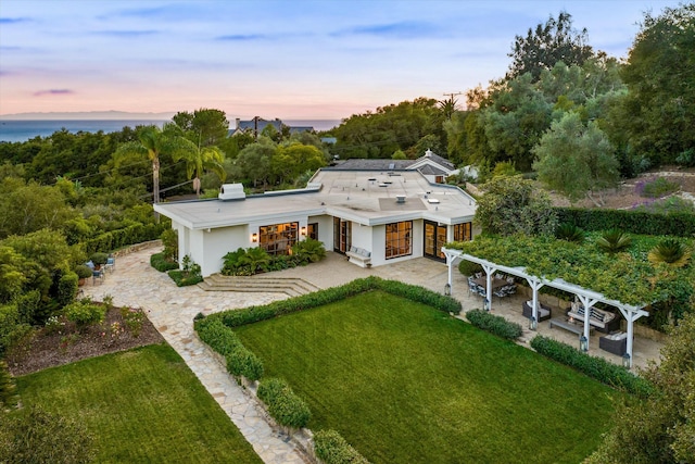 back of property featuring a patio area, a lawn, and a pergola