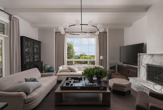 living room featuring carpet floors, a high end fireplace, a notable chandelier, and beam ceiling