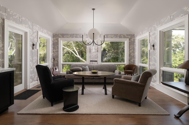 sunroom featuring lofted ceiling and a chandelier