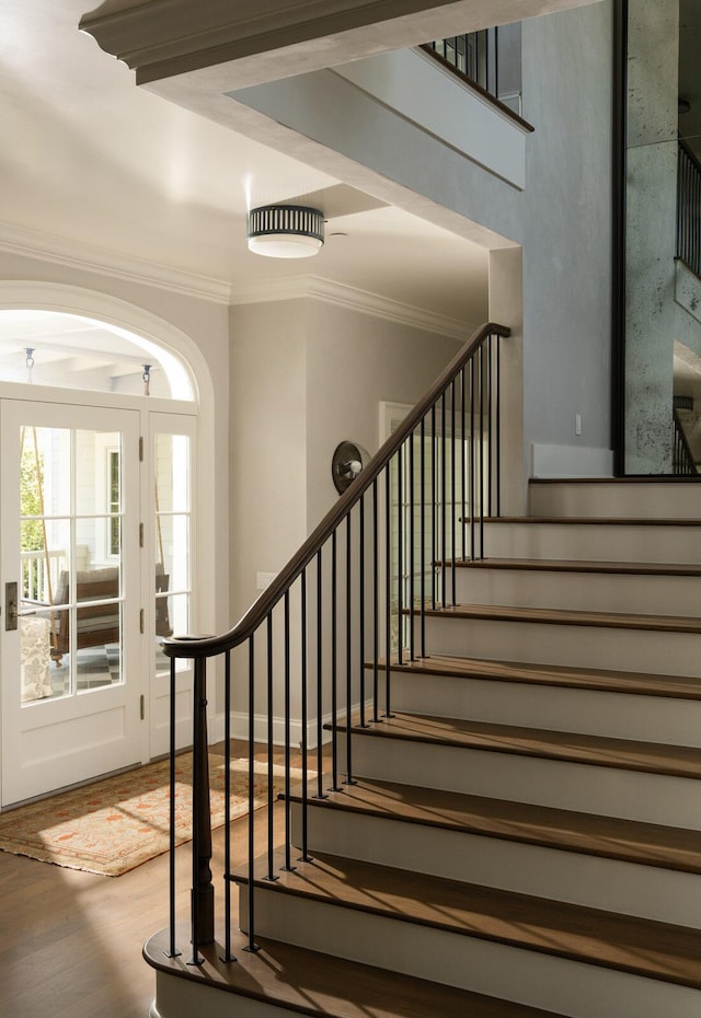 stairs featuring hardwood / wood-style flooring and ornamental molding