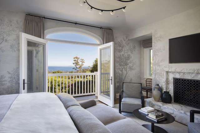 bedroom featuring track lighting, access to exterior, and a high end fireplace