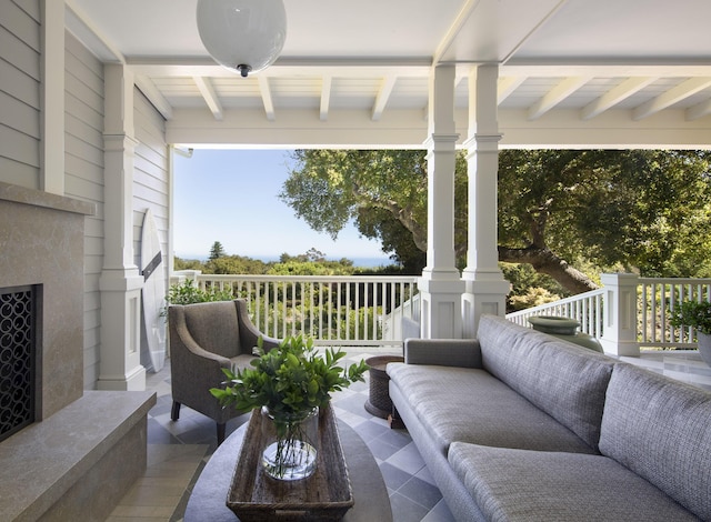 sunroom featuring an outdoor fireplace and beam ceiling