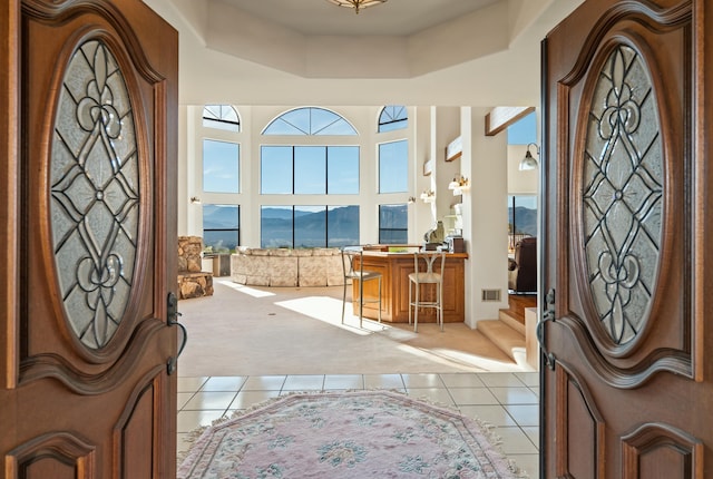 foyer with tile patterned flooring, a mountain view, and a high ceiling