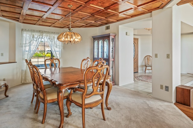 carpeted dining area with coffered ceiling and an inviting chandelier