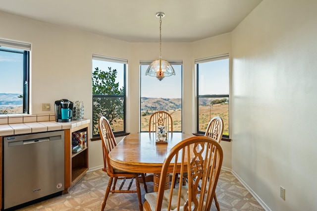 dining room featuring a mountain view and a healthy amount of sunlight