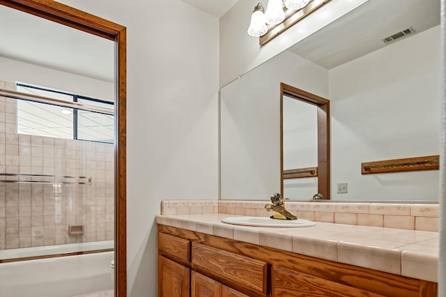 bathroom with vanity and enclosed tub / shower combo