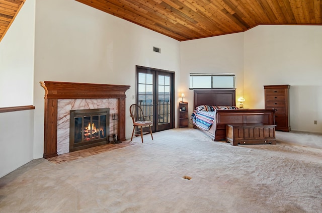 bedroom featuring a fireplace, light colored carpet, wood ceiling, and high vaulted ceiling