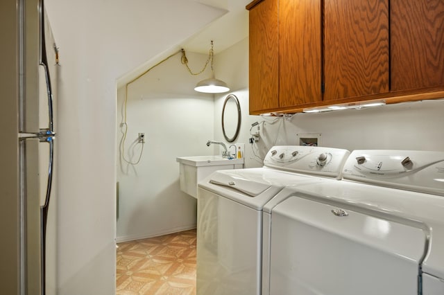 laundry room featuring washer and dryer, light parquet flooring, and cabinets