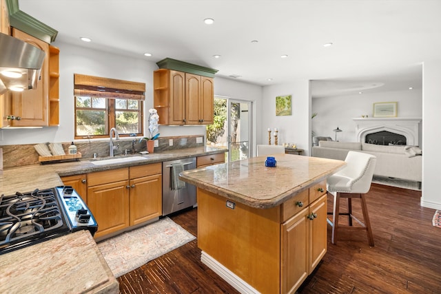 kitchen with sink, dark hardwood / wood-style flooring, stainless steel dishwasher, a breakfast bar, and a kitchen island