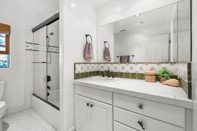 full bathroom with backsplash, tile patterned floors, vanity, enclosed tub / shower combo, and toilet