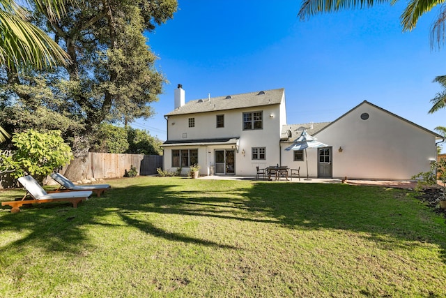 back of property featuring a patio and a lawn