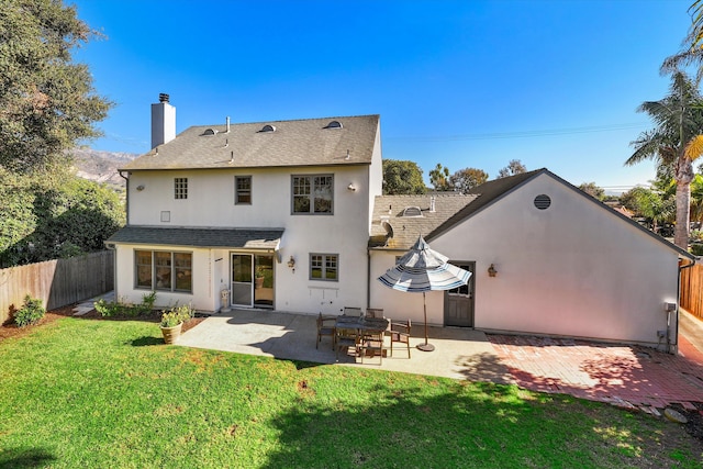 rear view of house featuring a yard and a patio