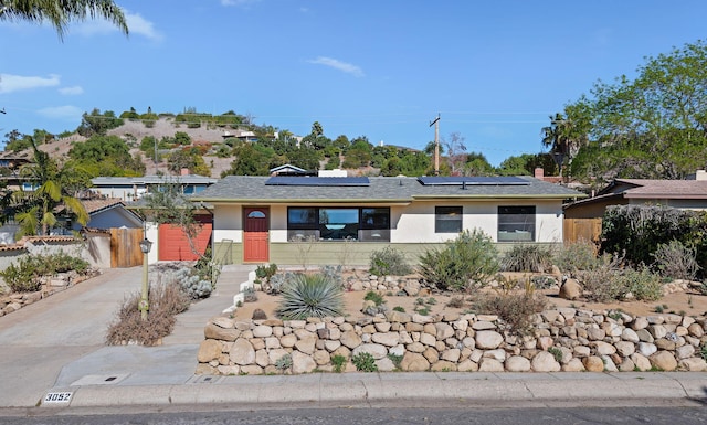 single story home featuring solar panels