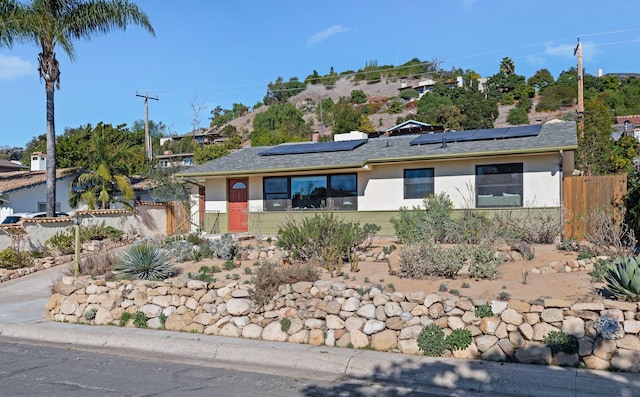 view of front of property featuring solar panels