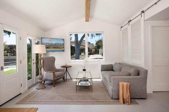 sitting room with vaulted ceiling with beams and a barn door