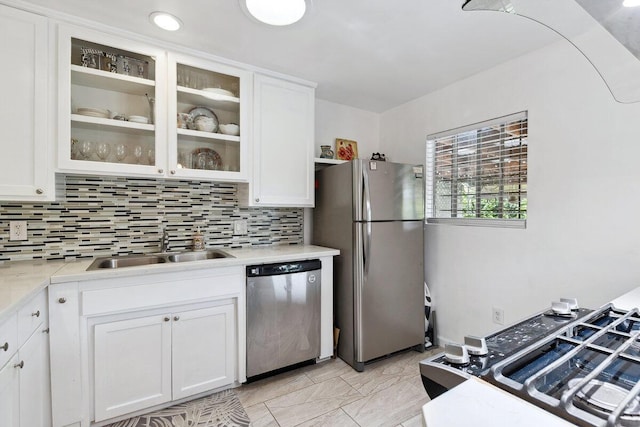 kitchen featuring backsplash, sink, white cabinets, and appliances with stainless steel finishes