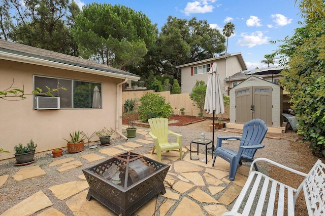 view of patio / terrace featuring a storage shed and an outdoor fire pit