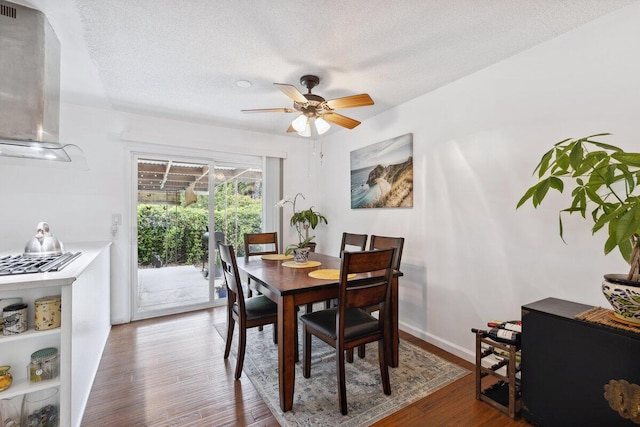 dining room featuring dark hardwood / wood-style floors, ceiling fan, and a textured ceiling