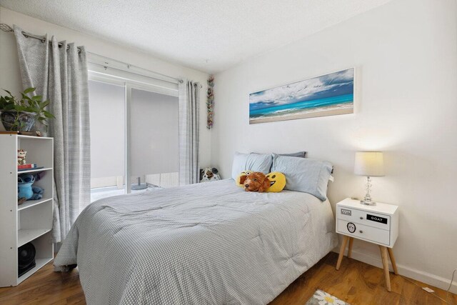 bedroom featuring a textured ceiling and dark wood-type flooring