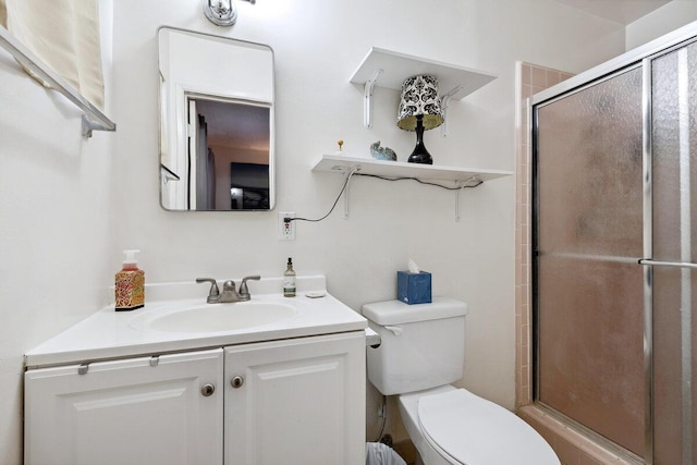 bathroom with vanity, a shower with shower door, and toilet