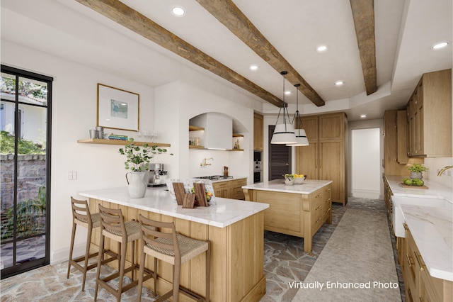 kitchen featuring kitchen peninsula, hanging light fixtures, beam ceiling, a breakfast bar, and a center island