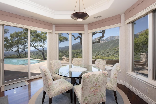 sunroom / solarium with a mountain view and a tray ceiling