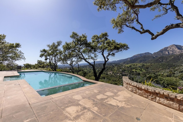 view of pool with a mountain view and a patio