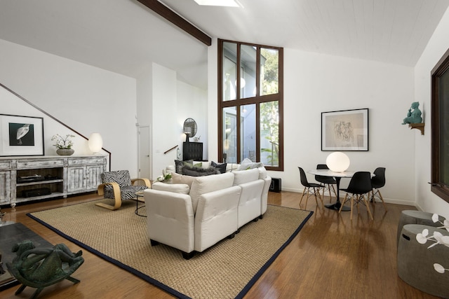 living room featuring hardwood / wood-style flooring and vaulted ceiling with beams