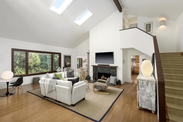 living room with hardwood / wood-style flooring, a skylight, high vaulted ceiling, and beamed ceiling