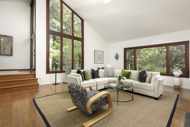 living room featuring a healthy amount of sunlight, hardwood / wood-style floors, and high vaulted ceiling