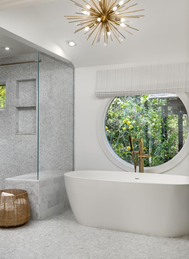 bathroom with a bathing tub and a notable chandelier